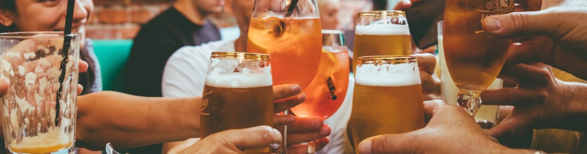 Hands holding beer glasses together