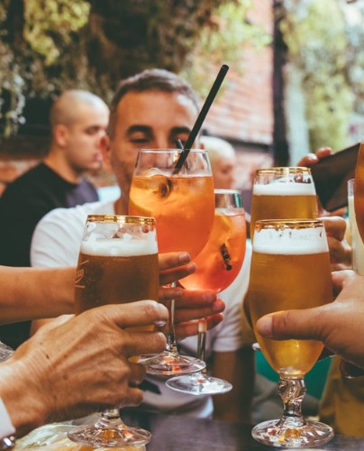 Hands holding beer glasses together