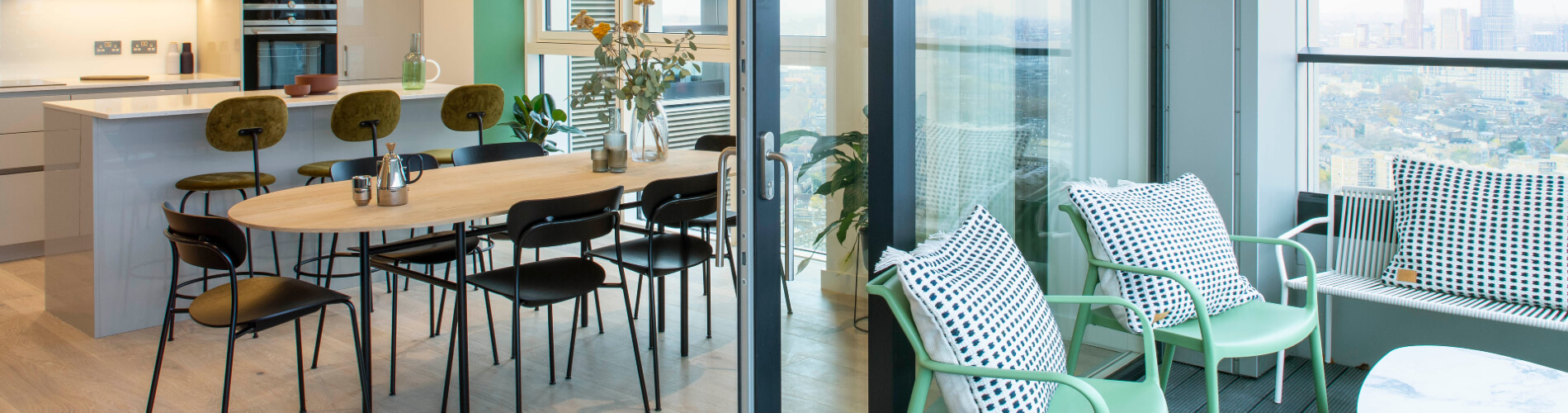 Green chairs with white crochet pillows on a balcony 