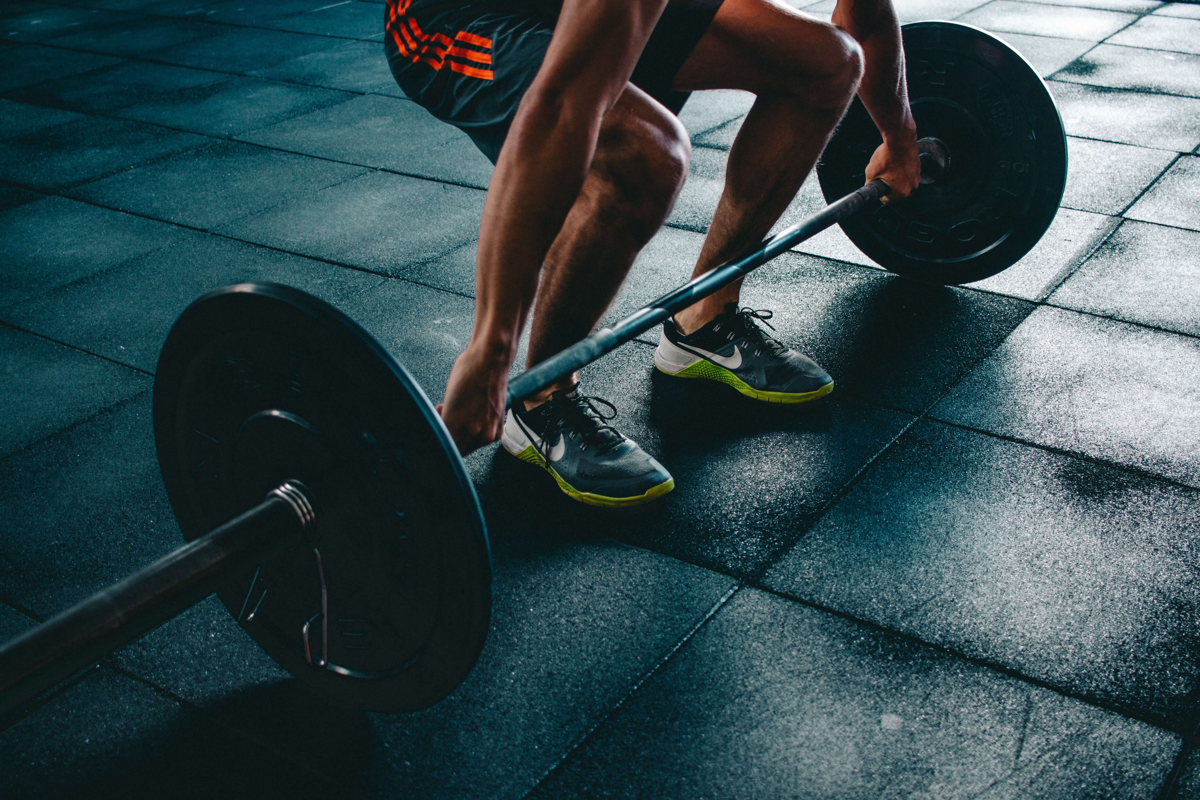 Man in running shoes lifts weights at one of the Elephant Park gyms 