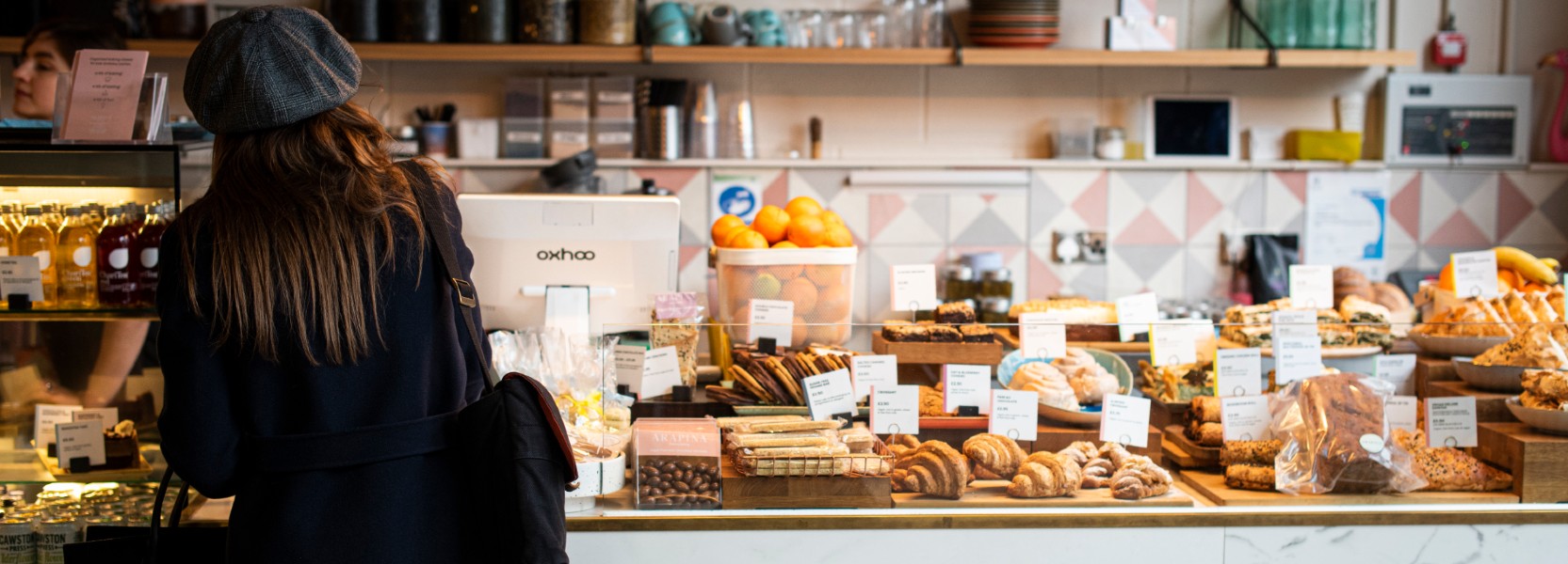 Girl standing with her back to the camera in front of cakes