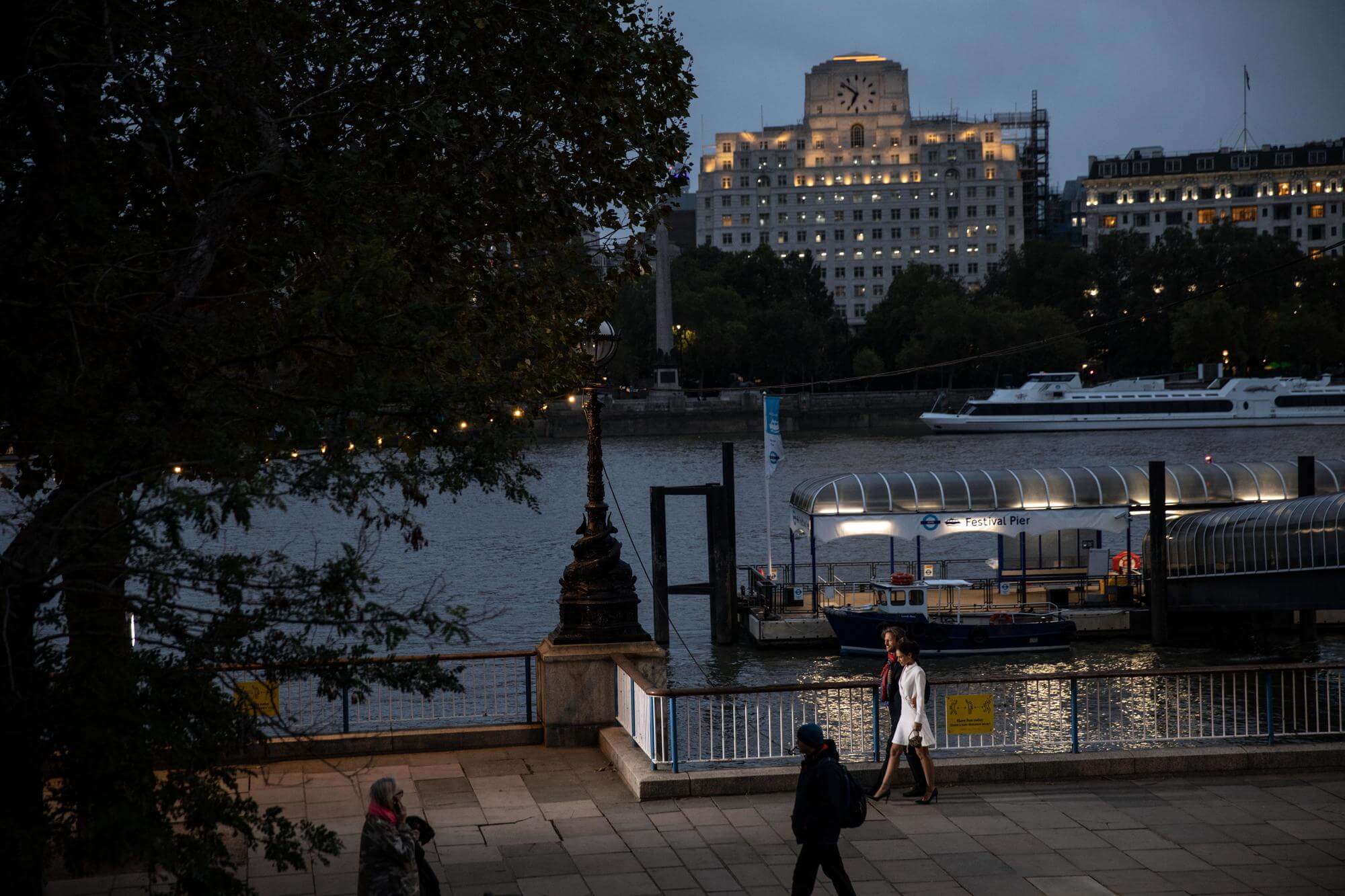 A couple walking through South Bank at night SE1